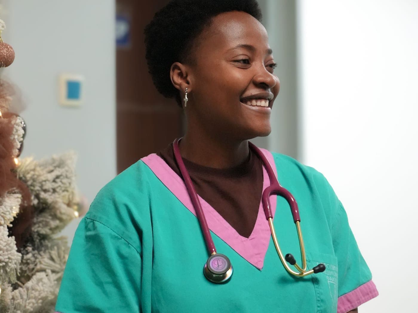 A nurse in scrubs on a clinic corridor