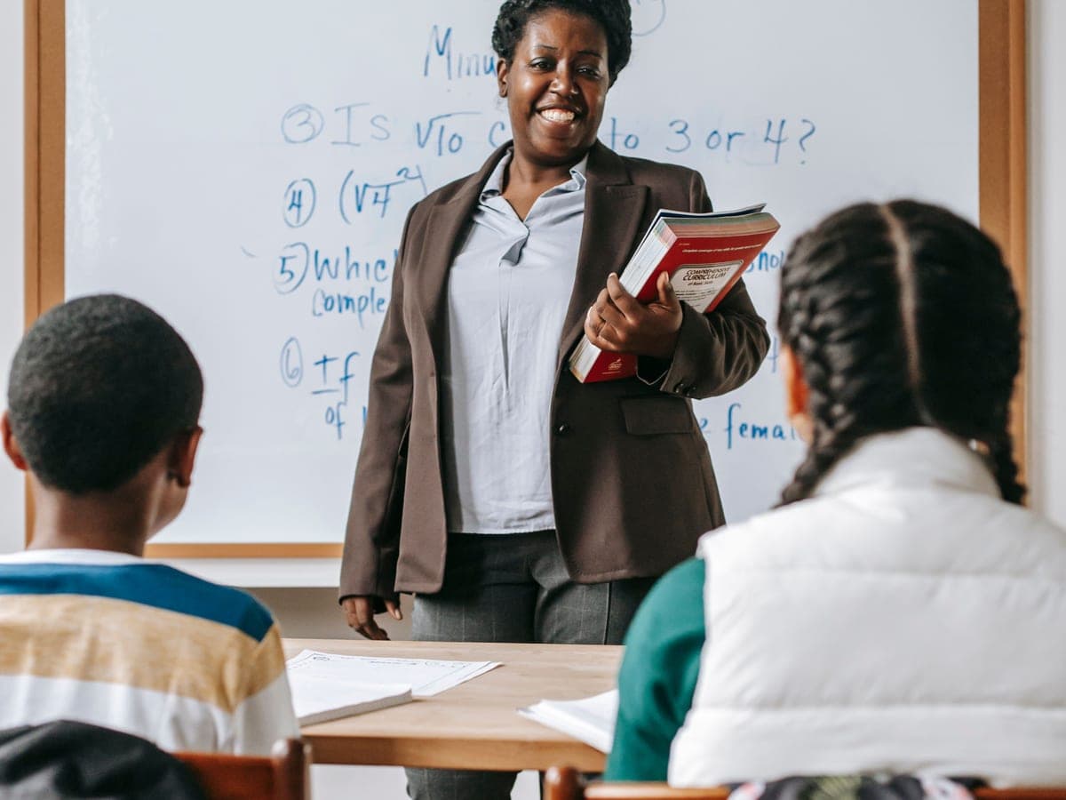 A teacher taking a maths lesson at the whiteboard
